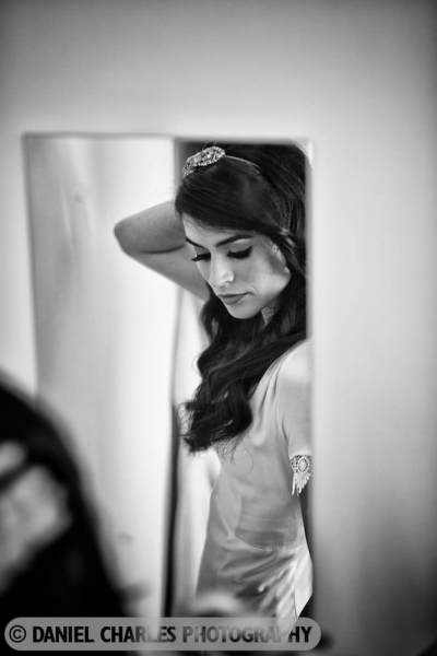the bride checks her appearance in a mirror black and white wedding photography