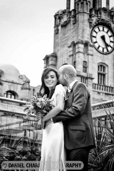 Bride and groom embracing with liver building in background by liverpool wedding photographer daniel charles photography