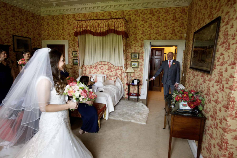 father of the bride sees his daughter in her wedding dress for the first time
