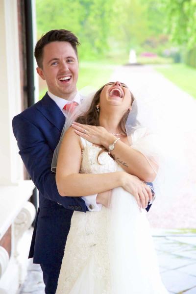 bride laughs after groom whispers in her ear