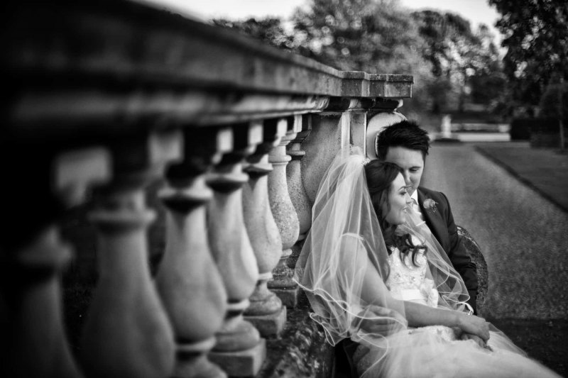 bride and  groom reclining on stone bench at knowsley hall