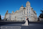 bride and groom kissing outside 3 graces in liverpool