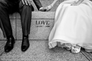 black and white wedding photo of bride and groom sitting on marble steps