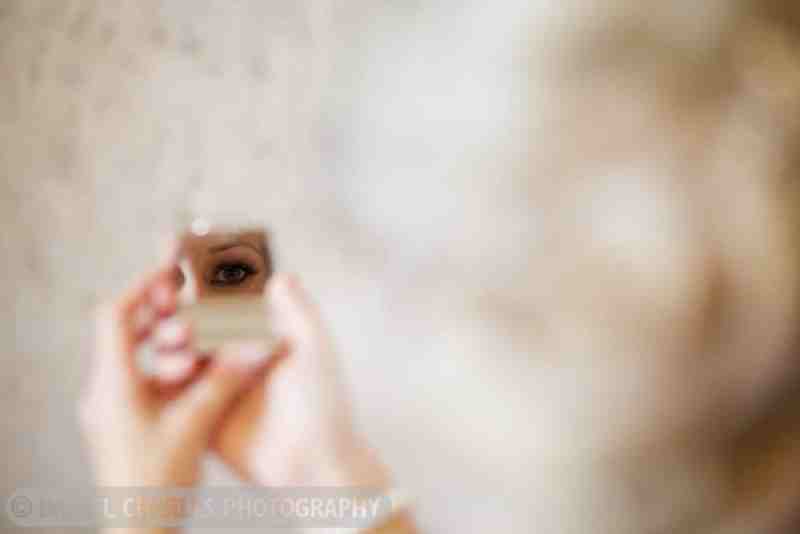 bride examining her makeup in compact mirror