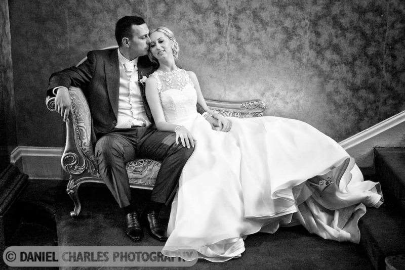 bride and groom seated on chaise longue