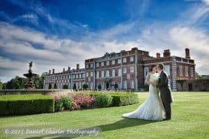 Bride and groom in gardens of Knowsley Hall with hall and fountain in background
