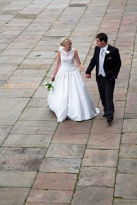 bride and groom walking hand in hand on sandstone slabs of plaza by st georges hall. Image by liverpool wedding photographer daniel charles photography